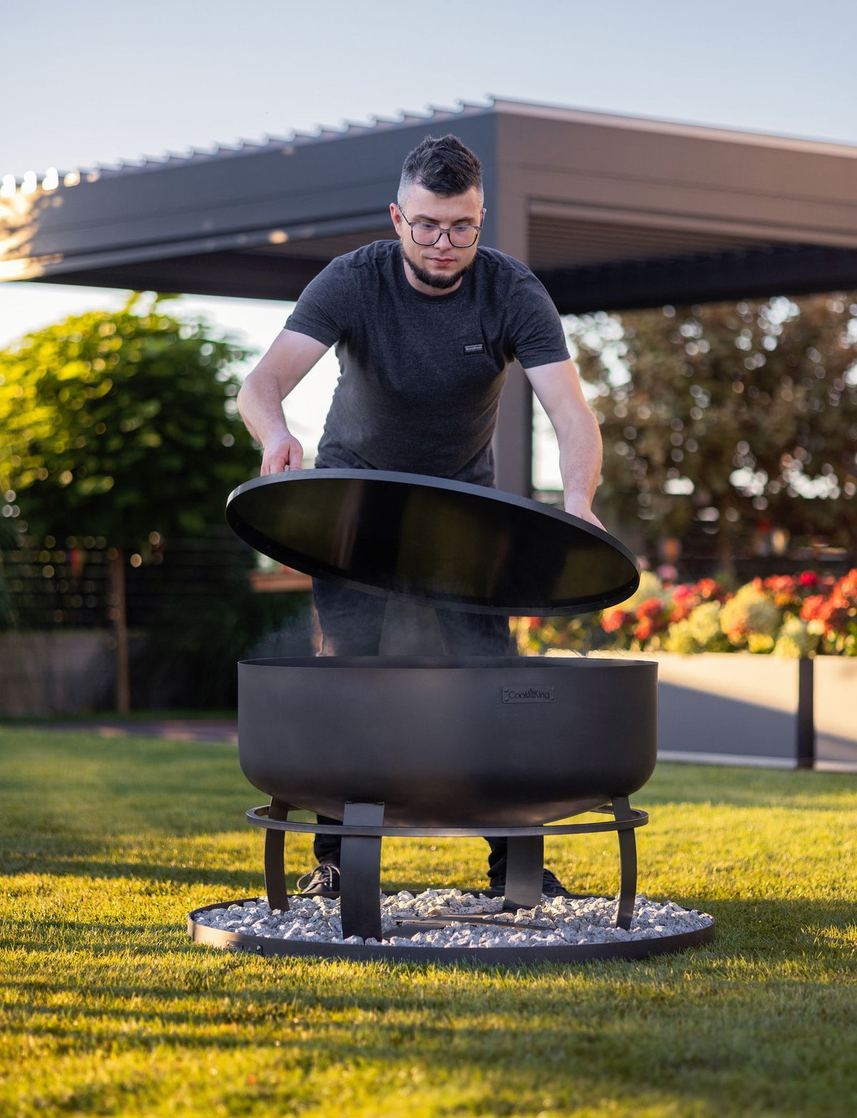 Cook King – Pack Brasero de jardin XXL « VIKING » 80 cm avec couvercle à bord profilé 81,5 cm et base décorative ronde en pierre 100 cm — mise en situation