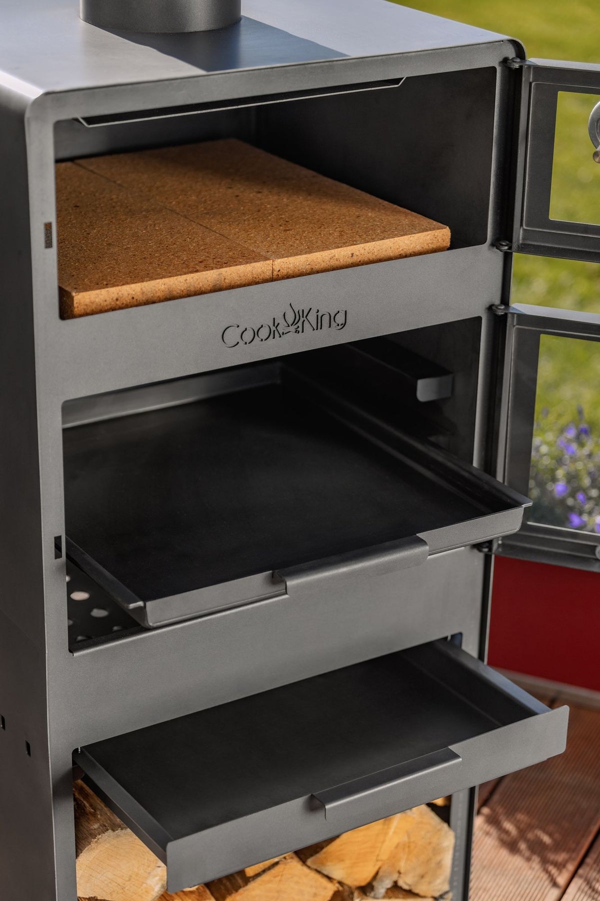 Cook King – Pack VENTO – Brasero cheminée avec four, grille de cuisson et range-bûches — mise en situation