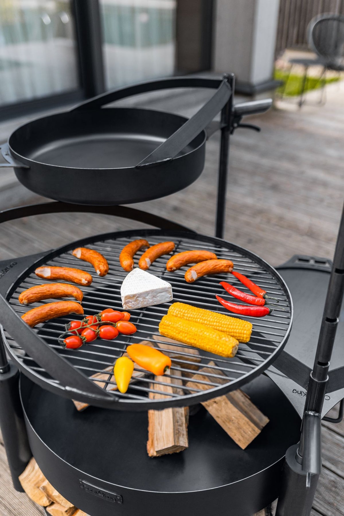 Cook King – Pack Brasero de jardin multifonction « MONTANA X » 80 cm avec grille de cuisson 60 cm, mât supplémentaire et poêle en acier brut 50 cm — mise en situation