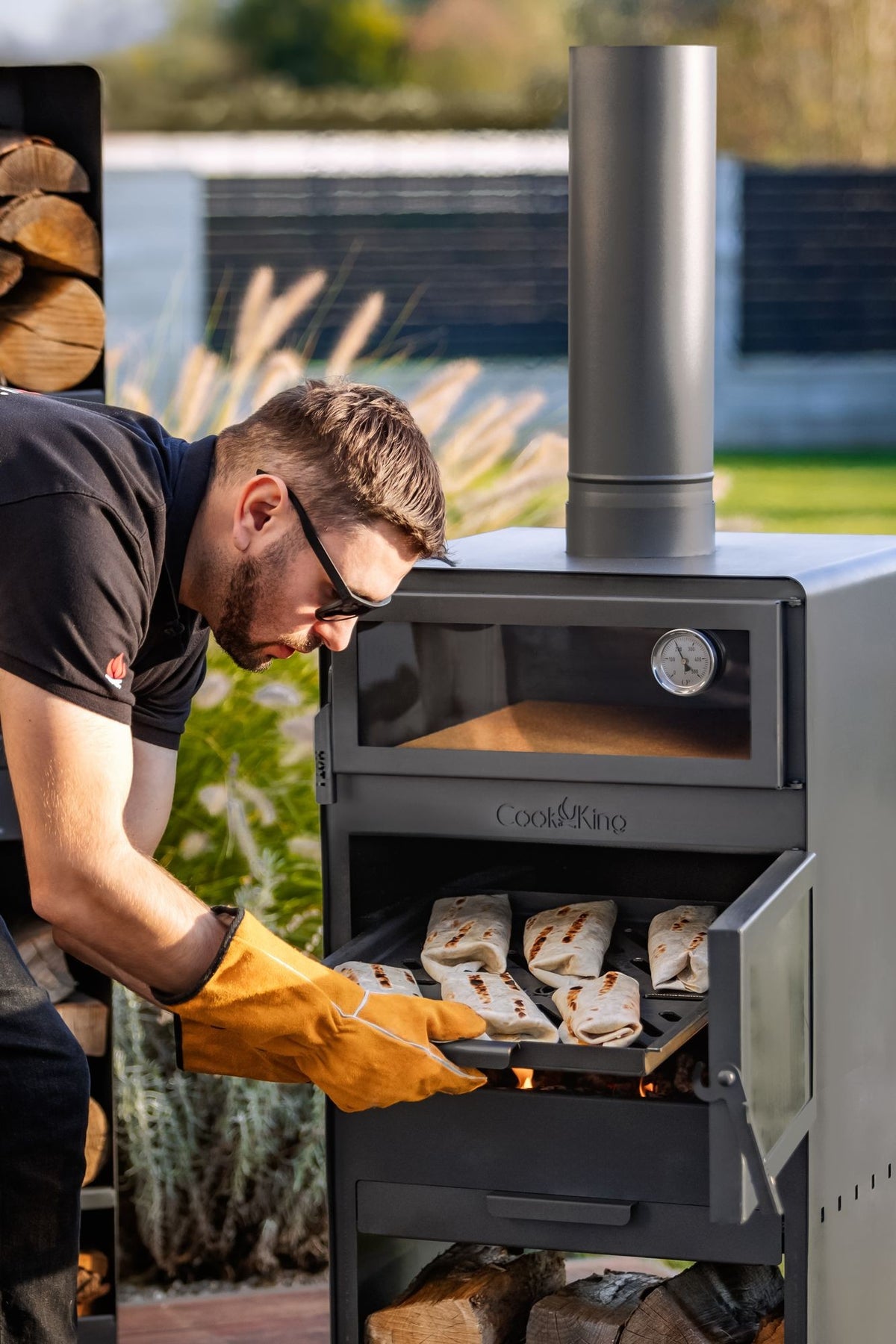 Cook King – Pack VENTO – Brasero cheminée avec four, grille de cuisson et range-bûches — mise en situation