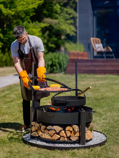 Cook King – Pack Brasero de jardin multifonction « MONTANA X » 80 cm avec grille de cuisson 60 cm, mât supplémentaire et poêle en acier brut 50 cm — mise en situation