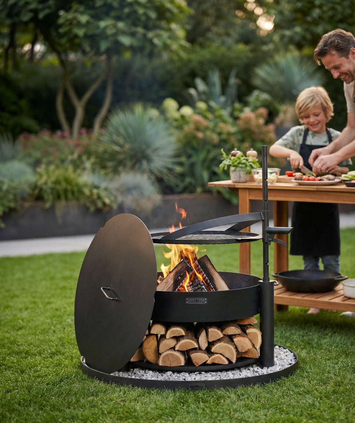 Cook King – Pack Brasero de jardin multifonction « MONTANA X » 80 cm avec grille de cuisson 60 cm, couvercle 82,0 cm et base décorative ronde en pierre 100 cm — mise en situation